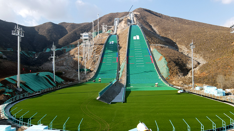 建设基地的赛道在设计中结合当地独特的山体条件，让崇礼滑雪跳台“雪如意”的两条赛道按照1:1的比例在此重现，被大家亲切地称为“雪吉祥”。“雪吉祥”滑雪跳台着陆坡采用土方填筑施工，建设者在世界首次将高铁施工中的高填方填筑技术应用于高山跳台滑雪工程，有效加固了土体，保证了土方填筑的稳定性，满足了设计沉降要求。图为大跳台和标准跳台两条赛道。