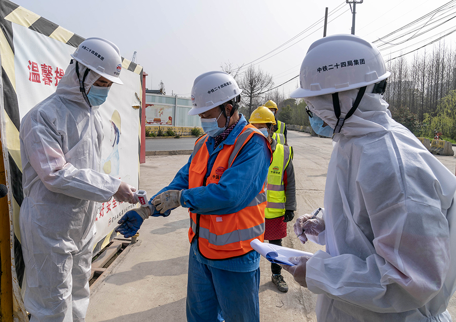 图为上海地铁15号线铺轨B标工人师傅上岗前体温测量。