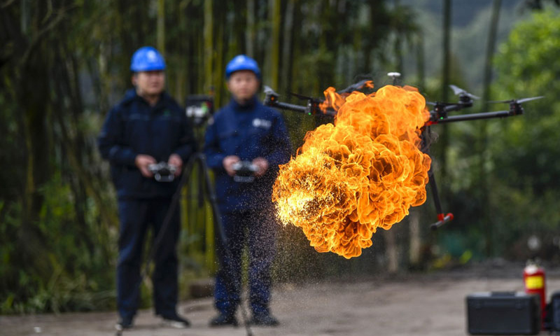 1月16日，经过3年多的研发和测试，重庆首台喷火清障无人机在国网重庆永川供电公司无人机班正式投用。图为喷火清障无人机在国网重庆永川供电公司无人机班两名操作手的控制下进行喷火清障作业演示。（新华社记者 刘潺 摄）