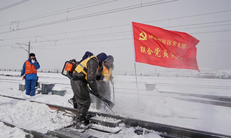 图为大雪过后，朔黄铁路神池南站党员突击队清扫积雪，保障铁路安全畅通。