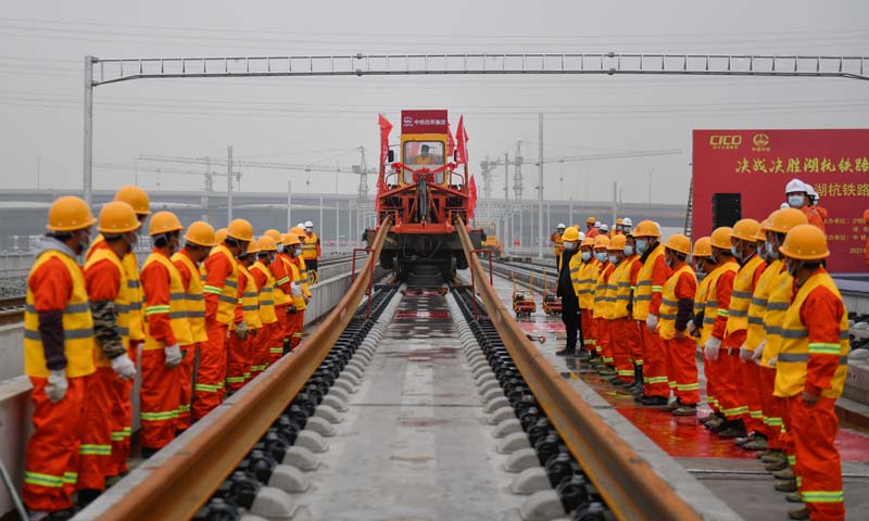 12月16日，在杭州西站西咽喉区湖杭铁路施工现场，首对500米长钢轨被安全平稳地铺设到无砟轨道道床上，标志着湖杭铁路正式进入全线铺轨阶段。图为中铁四局施工人员在湖杭铁路上进行铺轨作业。（新华社记者 黄宗治 摄）