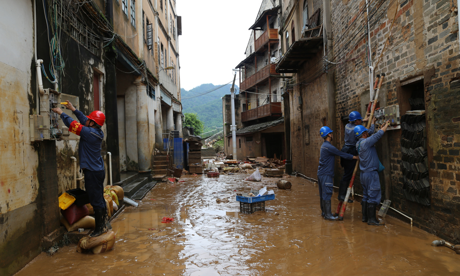 6月18日，广东梅州大埔茶阳镇的洪水逐渐退去，为尽快恢复当地的供用电正常，南方电网广东梅州大埔供电局茶阳供电所工作人员深入受灾现场，在落实好现场安全措施后，对故障电表进行检修、更换。郭丽燕 摄