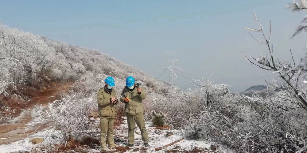 2月14日，湖北送变电公司工作人员在广水市武胜关镇牛脊山±800千伏陕武线1898号塔下观测线路覆冰情况并测风速。