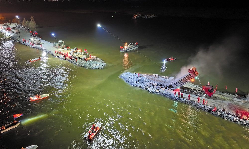 7月5日下午，湖南岳阳华容县团洲垸洞庭湖一线堤防发生决口，堵口作业于6日启动。国家电网有限公司调集8台系留式无人机，为华容团洲垸溃堤决口合龙提供应急照明。7月8日22时31分左右，团洲垸洞庭湖大堤226米决口完成封堵。图为国家电网电力抢险人员为洞庭湖大堤决口合龙现场提供应急照明。