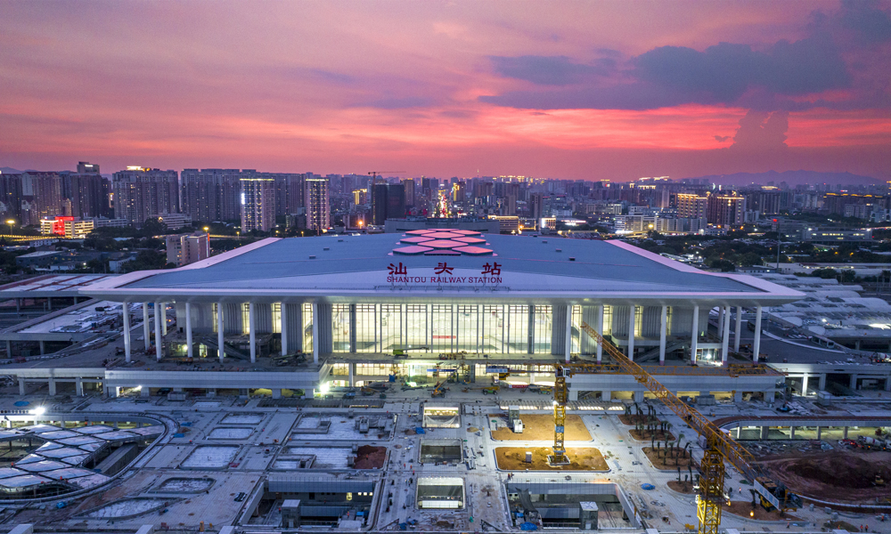 由中铁建设承建的新建汕头站是国家“八纵八横”沿海高铁的重要节点。工程共分两期，一期新建东站房，二期改扩建既有西站房，建筑规模10万平方米。建成后汕头站将成为集高铁、普铁、城际、地铁为一体的综合枢纽。当前，一期站房工程已进入静态验收阶段，1200余名建设者战高温保进度，各项施工作业正全力冲刺收尾。图为正在施工中的汕头站夜景。