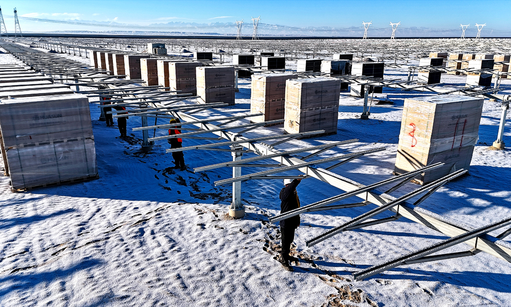 茫茫白雪中，中国绿发的建设者们在现场检查光伏支架情况。