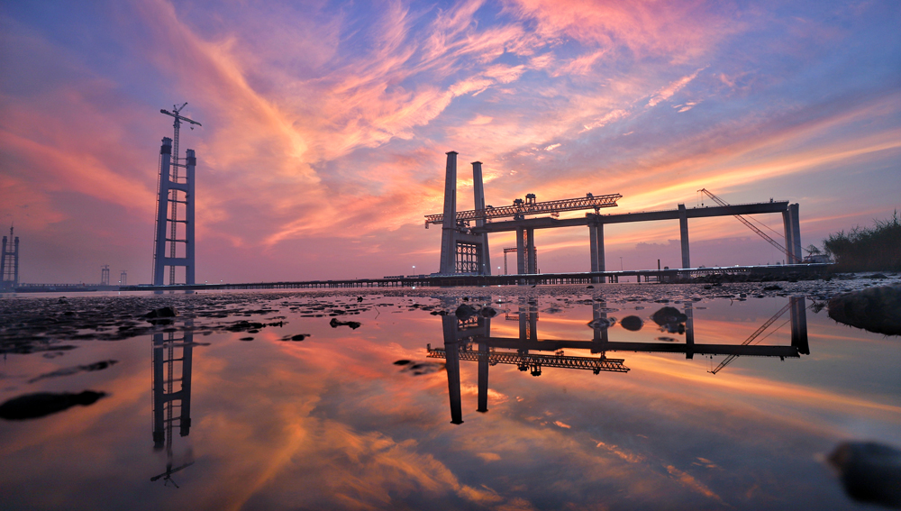 落日熔金映江天，霞光万道染塔尖。目前，中国交建旗下中交二航局承建的张靖皋长江大桥南主塔建设高度已超300米，预计2025年底可实现封顶，届时高度将达350米，为世界最高悬索桥索塔。