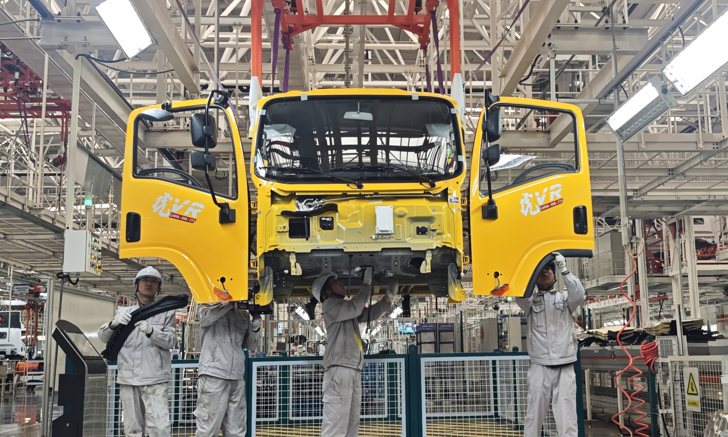 一汽解放青岛汽车有限公司工作人员在总装生产线进行轻卡驾驶室装配。