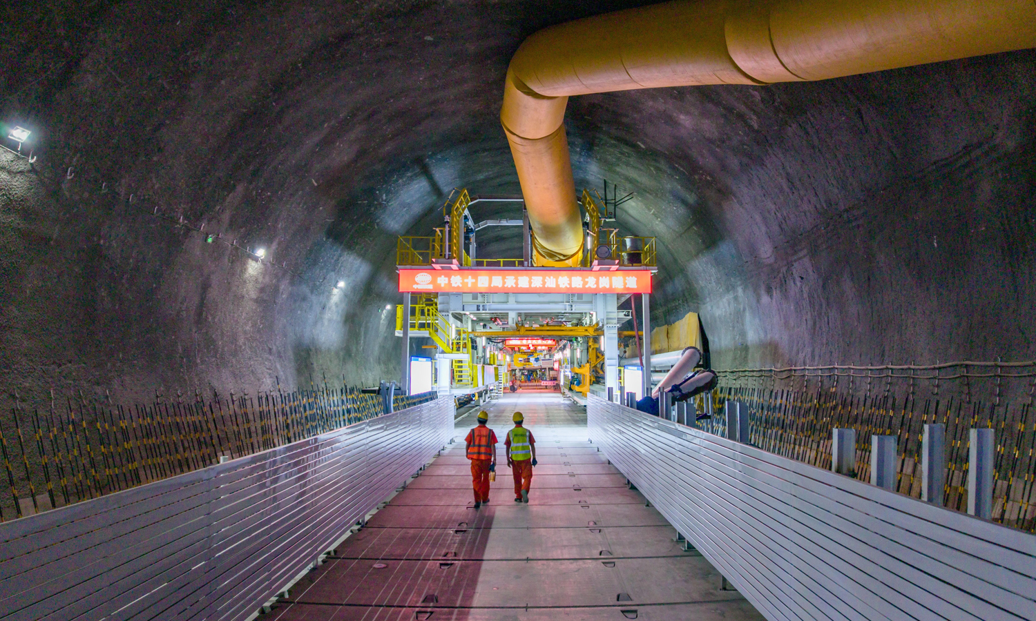 龙岗隧道穿行于深圳城区中心，地面建筑密集、交通繁忙，不具备常规从地面始发井盾构掘进的条件。项目团队攻克多项行业难题，创新实现盾构机洞内组装、空推、始发、接收、拆解及回拖全流程作业，并首创原位翻身、无托架长距离空推、无负环始发等新工艺，大幅提升施工效率与精度。图为隧道内景。