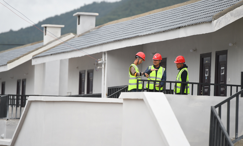  近日，航天建设管理人员对日久村住房进行检查。（宿东 摄） 